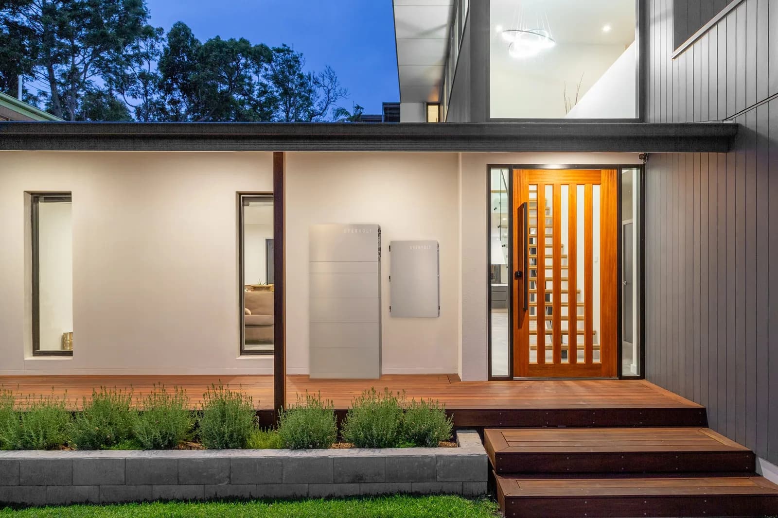 Panasonic EVERVOLT battery and SmartBox installed on the exterior wall of a modern home at dusk